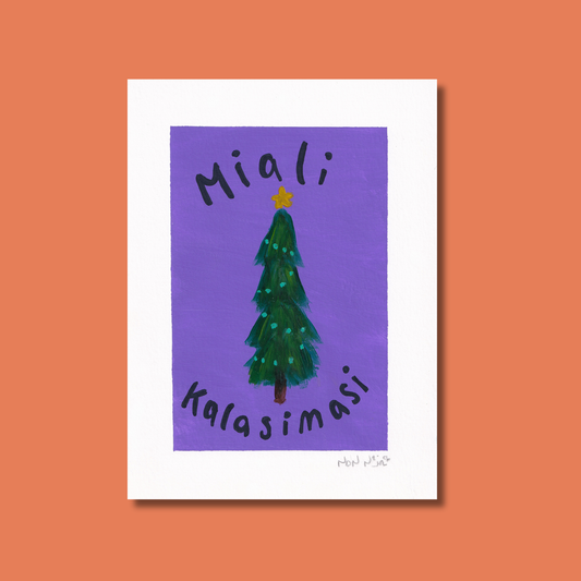 Hand-painted artwork titled ‘Miali Kalasimasi,’ featuring a tall green Christmas tree decorated with teal ornaments and topped with a small yellow star. The Inuktitut syllabics and Romanized text spell ‘Miali Kalasimasi,’ meaning ‘Merry Christmas.’ The tree stands against a vibrant purple background, with the piece set on a warm coral backdrop that enhances the festive, heartfelt tone.