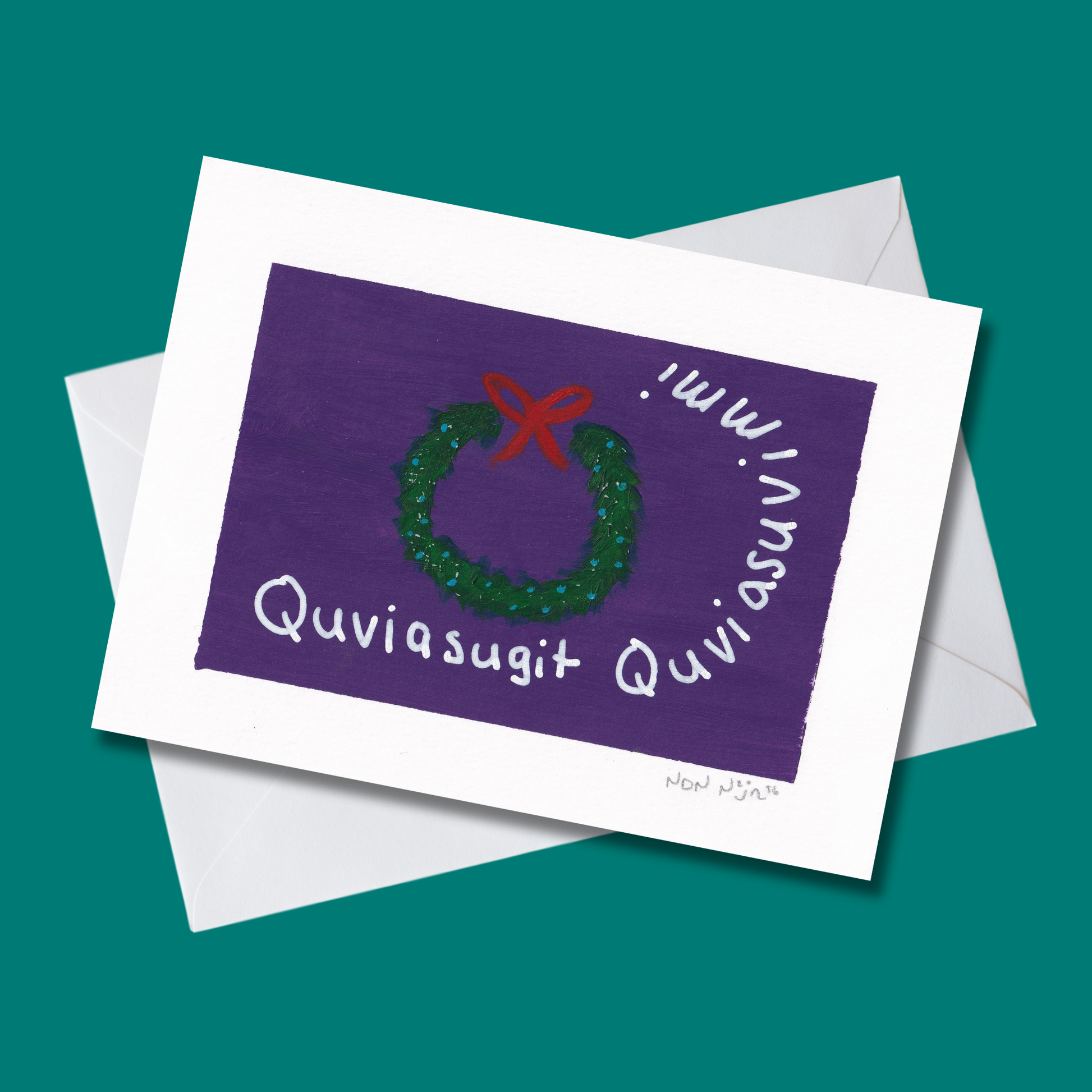 Hand-painted ‘Quviasugit Quviasuvik’ artwork displayed at an angle over a teal background with a white envelope. The piece features a green wreath with a red bow against a deep purple backdrop, surrounded by the Inuktitut phrase ‘Quviasugit Quviasuvik,’ meaning ‘Merry Christmas.’ The composition evokes festive warmth and Northern celebration through rich contrast and gentle brush texture.