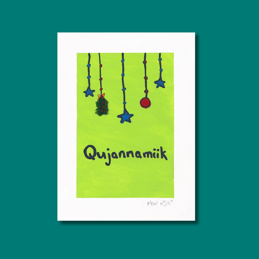 A bright green greeting card with the Inuktitut word ‘Qujannamiik,’ meaning thank you. The hand-painted artwork features hanging blue stars, a red ornament, and a small green sprig, symbolizing gratitude and joy.