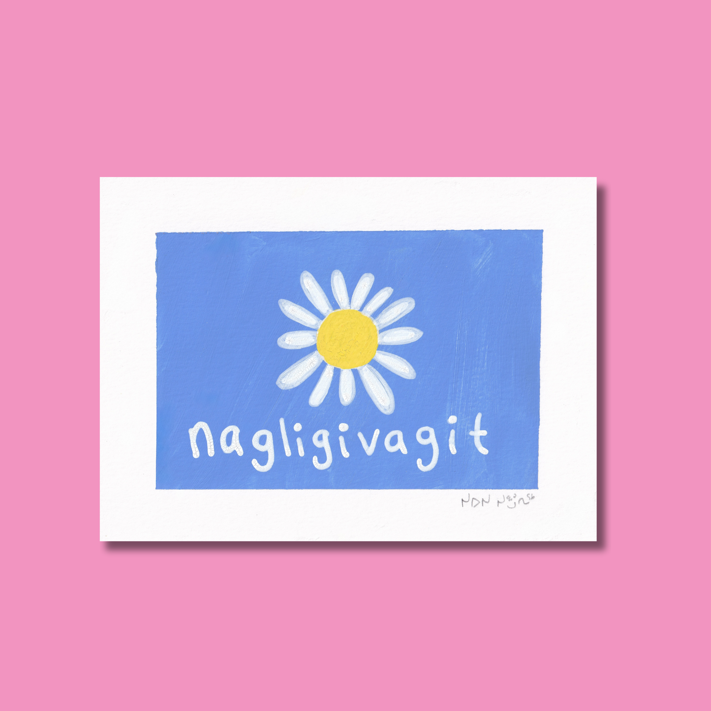 Hand-painted artwork titled ‘Nagligivagit,’ featuring a white daisy with a bright yellow centre on a vivid blue background. The Inuktitut word ‘Nagligivagit,’ meaning ‘I love you,’ is written below in soft white script. The piece is photographed against a pink backdrop, creating a tender, joyful contrast that evokes warmth and affection.