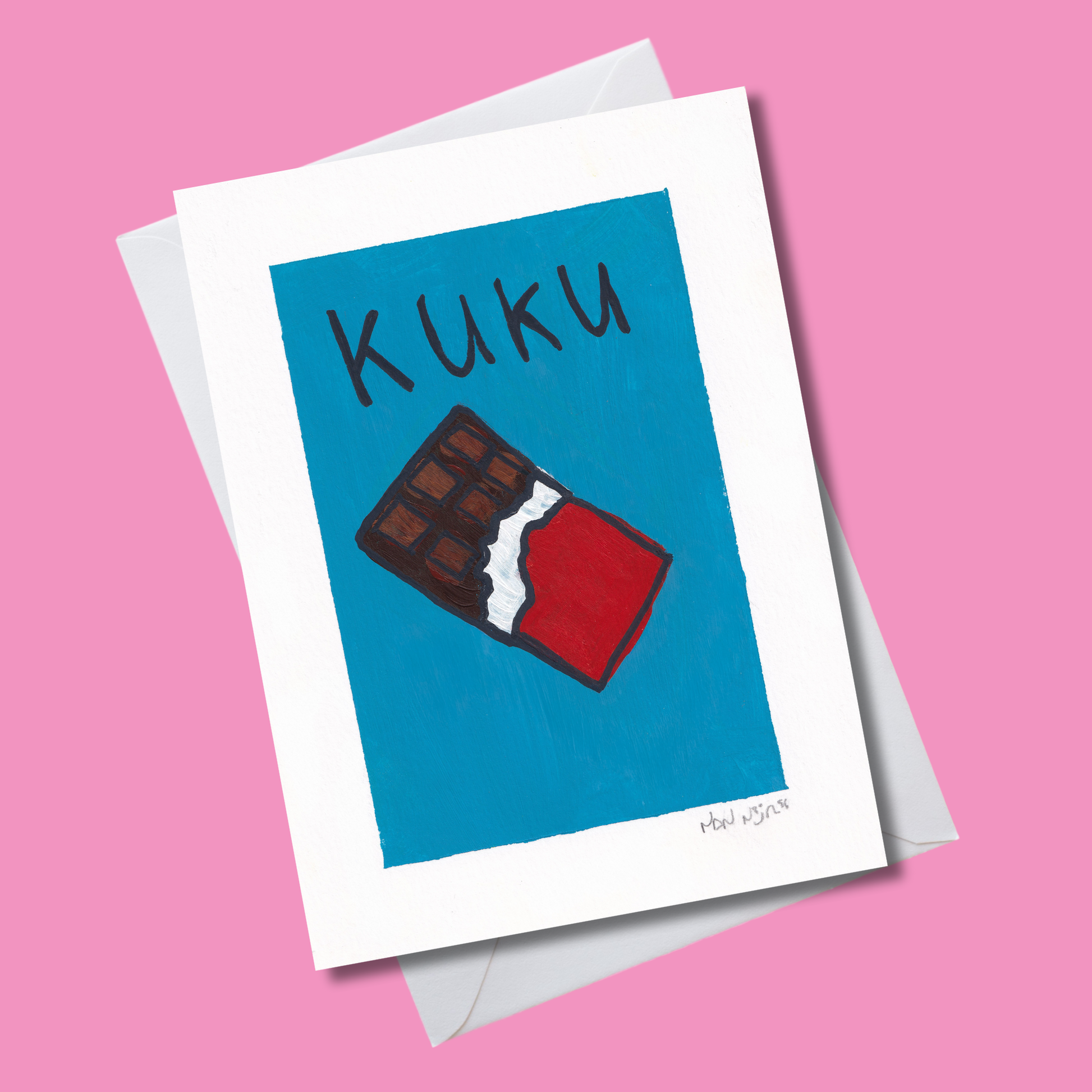 Hand-painted ‘Kuku’ card featuring a chocolate bar illustration on a blue background, photographed at an angle on a pink backdrop with white envelope.